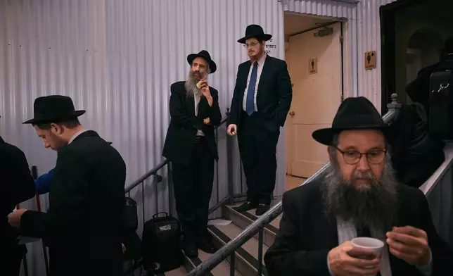 Chabad-Lubavitch rabbis take a break near the resting place of the Rebbe, Rabbi Menachem M. Schneerson, one of Judaism’s most influential figures, in the Queens borough of New York on Friday, Nov. 14, 2025, during the International Conference of Chabad-Lubavitch Emissaries. (AP Photo/Andres Kudacki)