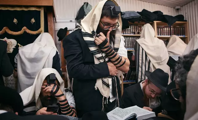 Chabad-Lubavitch rabbis gather in prayer at the resting place of the Rebbe, Rabbi Menachem M. Schneerson, one of Judaism’s most influential figures, in the Queens borough of New York on Friday, Nov. 14, 2025, during the International Conference of Chabad-Lubavitch Emissaries. (AP Photo/Andres Kudacki)