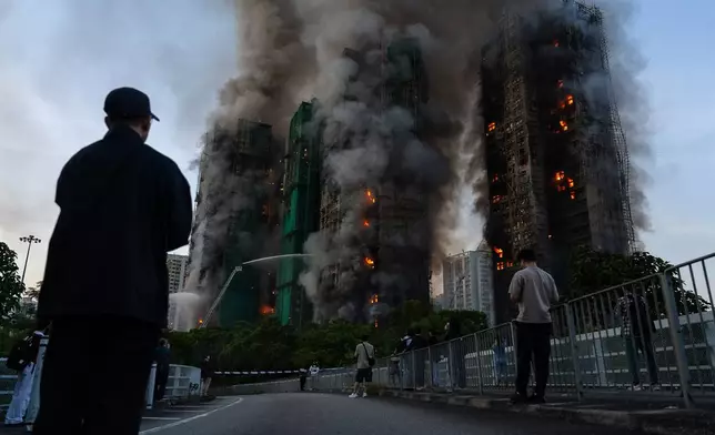 Smoke rises after a fire broke out at Wang Fuk Court, a residential estate in the Tai Po district of Hong Kong's New Territories on Wednesday, Nov. 26 2025. (AP Photo/Chan Long Hei)