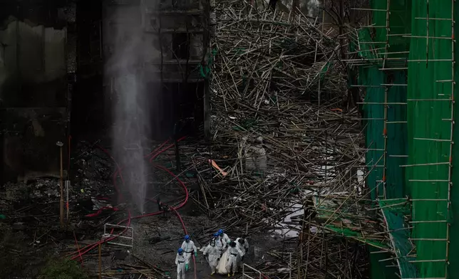 Emergency crew remove what appears to be a body bag from the site of a deadly Wednesday fire at Wang Fuk Court, a residential estate in the Tai Po district of Hong Kong's New Territories on Sunday, Nov. 30, 2025. (AP Photo/Ng Han Guan)