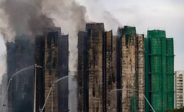 Firefighters work to extinguish a fire which broke out Wednesday at Wang Fuk Court, a residential estate in the Tai Po district of Hong Kong's New Territories, Thursday, Nov. 27, 2025. (AP Photo/Chan Long Hei)