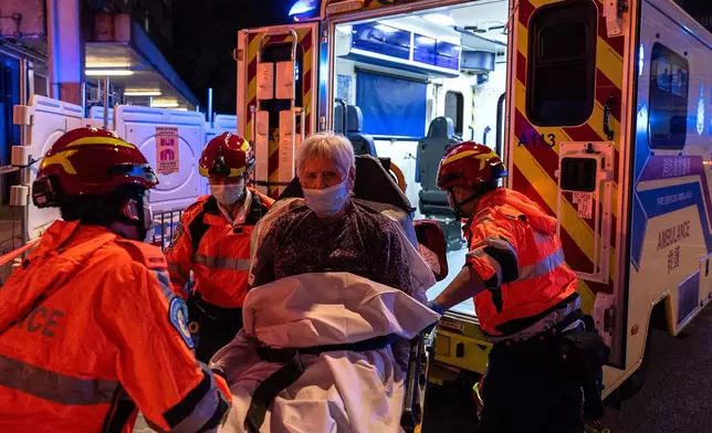 An injured person is lifted into an ambulance after a fire broke out at Wang Fuk Court, a residential estate in the Tai Po district of Hong Kong's New Territories, Wednesday, Nov. 26 2025. (AP Photo/Chan Long Hei)