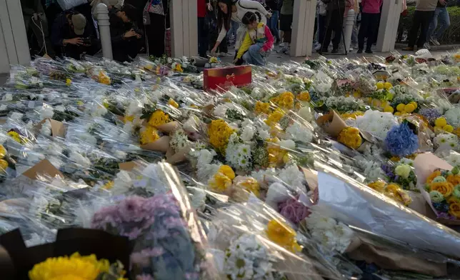 Flowers are placed near the site of the deadly Wednesday fire at Wang Fuk Court, a residential estate in the Tai Po district of Hong Kong's New Territories on Saturday, Nov. 29, 2025. (AP Photo/Ng Han Guan)