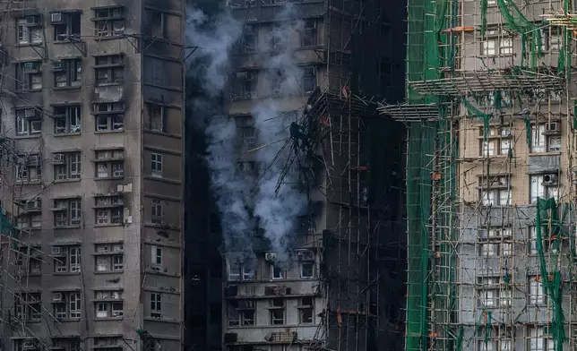 Smoke coming out of a burned building is seen at the scene of the fire at Wang Fuk Court, a residential estate in the Tai Po district of Hong Kong's New Territories, Friday, Nov. 28 2025. (AP Photo/Chan Long Hei)