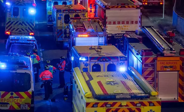 Ambulances and firefighter trucks are parked after a fire broke out at Wang Fuk Court, a residential estate in the Tai Po district of Hong Kong's New Territories, Wednesday, Nov. 26 2025. (AP Photo/Chan Long Hei)