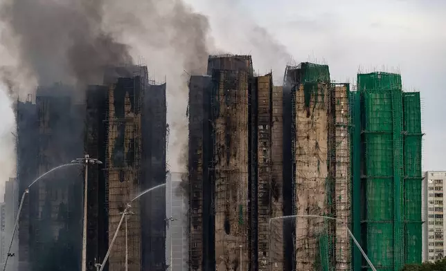 Firefighters work to extinguish a fire which broke out Wednesday at Wang Fuk Court, a residential estate in the Tai Po district of Hong Kong's New Territories, Thursday, Nov. 27, 2025. (AP Photo/Chan Long Hei)