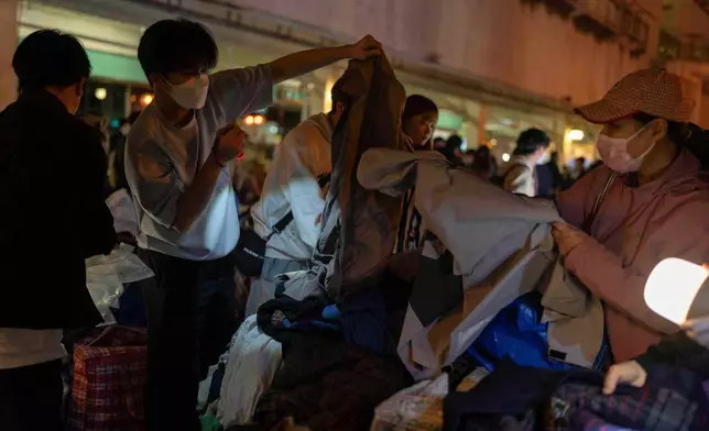 Volunteers provide warm clothings for residents in the aftermath of a fire at Wang Fuk Court, a residential estate in the Tai Po district of Hong Kong's New Territories, Thursday, Nov. 27 2025. (AP Photo/Ng Han Guan)