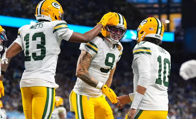 Green Bay Packers wide receiver Christian Watson (9) celebrates a touchdown with wide receiver Dontayvion Wicks (13) and quarterback Jordan Love (10) against the Detroit Lions during the second half an NFL football game in Detroit, Thursday, Nov. 27, 2025. (AP Photo/Ryan Sun)