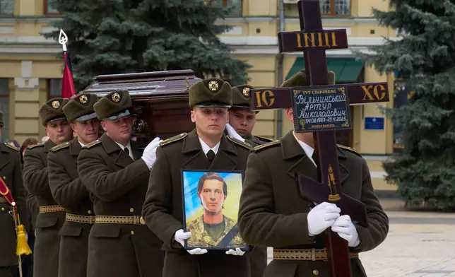 Servicemen carry coffins of their fellow soldiers Myroslava Kopcha and Artur Vilchynski, who were killed in Russia-Ukraine war, during a funeral ceremony at St. Michael Cathedral in Kyiv, Ukraine, Friday, Nov. 28, 2025. (AP Photo/Efrem Lukatsky)