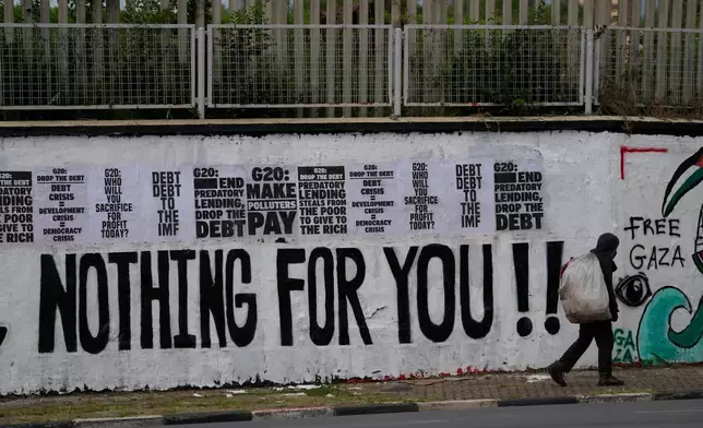 A man walks past an anti G20 graffiti in Johannesburg, South Africa, Saturday, Nov. 22, 2025. (AP Photo/Themba Hadebe)
