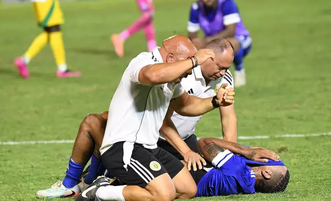Curacao players and trainers celebrate qualifying for the 2026 FIFA World Cup after their game with Jamaica in Kingston, Jamaica, Tuesday, Nov. 18, 2025. (AP Photo/Collin Reid)