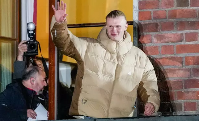 Erling Haaland greets the people from the city hall balcony after the victory in the World Cup qualifying match between Norway and Italy at San Siro, in Oslo, Monday, Nov. 17, 2025. (Heiko Junge/NTB via AP)