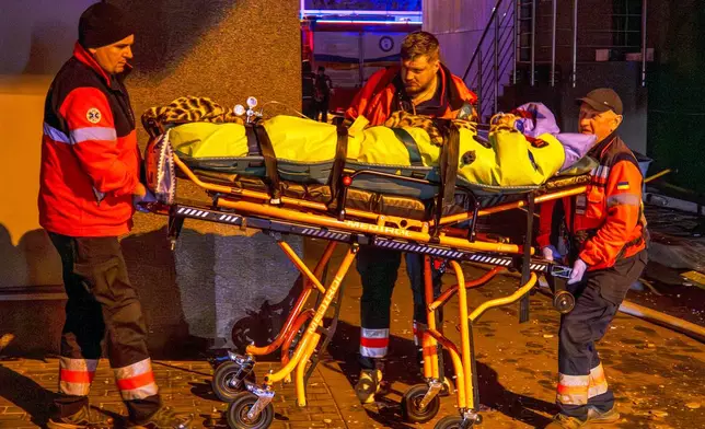 Rescue workers carry a person from a residential building following a Russian attack in Kyiv, Ukraine, Tuesday, Nov. 25, 2025. (AP Photo/Dan Bashakov)