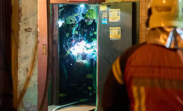 Rescuers carry the body of a civilian who was killed as a drone hit a multi-storey residential building during Russia's night drone attack in Kyiv, Ukraine, Tuesday, Nov. 25, 2025. (AP Photo/Efrem Lukatsky)