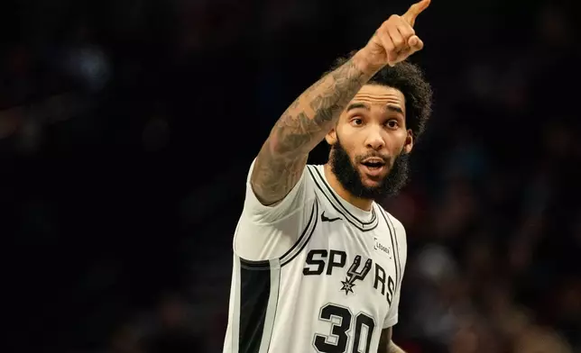 San Antonio Spurs forward Julian Champagnie (30) gives instructions to his teammates during the first half of an Emirates NBA Cup basketball game against the Portland Trail Blazers, Wednesday, Nov. 26, 2025, in Portland, Ore. (AP Photo/Ali Gradischer)