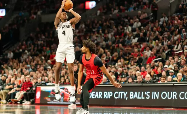 San Antonio Spurs guard De'Aaron Fox (4) shoots a three point shot over Portland Trail Blazers guard Shaedon Sharpe (17) during the first half of an Emirates NBA Cup basketball game, Wednesday, Nov. 26, 2025, in Portland, Ore. (AP Photo/Ali Gradischer)
