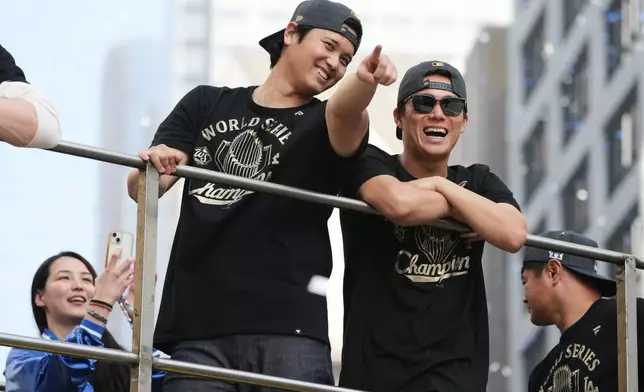 Los Angels Dodgers' Shohei Ohtani, left, and Yoshinobu Yamamoto ride on a double-decker bus during a parade to celebrate the baseball team's World Series win on Monday, Nov. 3, 2025, in Los Angeles. (AP Photo/Jae C. Hong)