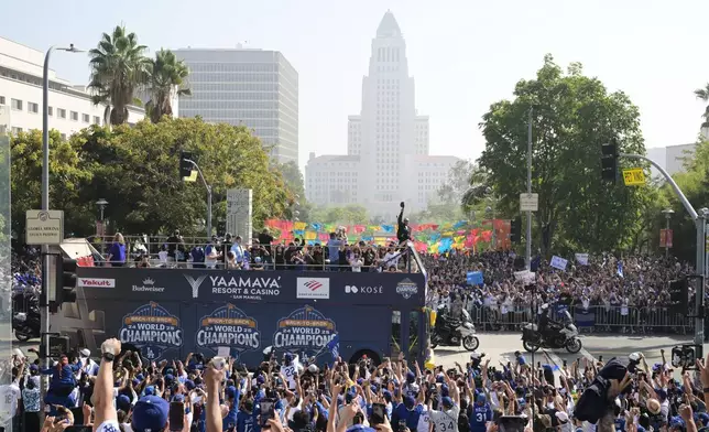 Los Angeles Dodgers players, family and staff ride on top of double-decker buses during a parade to celebrate the baseball team's World Series win on Monday, Nov. 3, 2025, in Los Angeles. (AP Photo/Kyusung Gong)