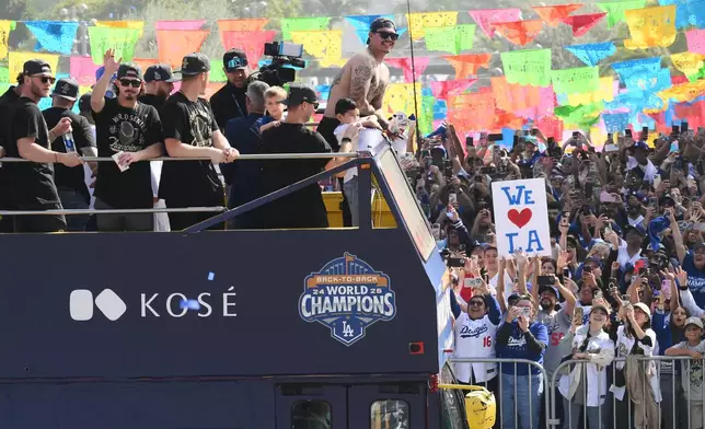 Los Angeles Dodgers players, family and staff ride on top of double-decker buses during a parade to celebrate the baseball team's World Series win on Monday, Nov. 3, 2025, in Los Angeles. (AP Photo/Kyusung Gong)