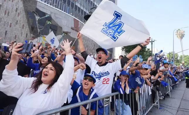 Fans cheer along the route during a parade to celebrate the Los Angeles Dodgers baseball team's World Series win on Monday, Nov. 3, 2025, in Los Angeles. (AP Photo/Jae C. Hong)