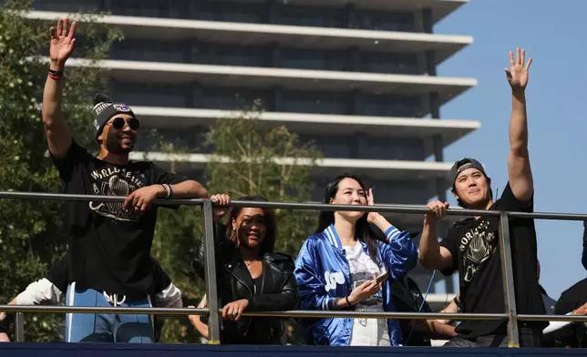 Los Angeles Dodgers' Mookie Betts, left, and Shohei Ohtani wave at fans during a parade to celebrate the baseball team's World Series win on Monday, Nov. 3, 2025, in Los Angeles. (AP Photo/Jae C. Hong)