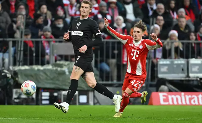 Bayern Munich's Lennart Karl and St. Pauli's Eric Smith, left, in action during the Bundesliga soccer match between Bayern Munich and FC St. Pauli in Munich, Germany, Saturday Nov. 29, 2025. (Sven Hoppe/dpa via AP)