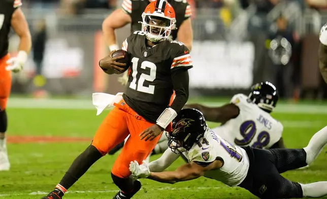 Cleveland Browns quarterback Shedeur Sanders (12) is stopped by Baltimore Ravens safety Kyle Hamilton (14) in the second half of an NFL football game in Cleveland, Sunday, Nov. 16, 2025. (AP Photo/Sue Ogrocki)