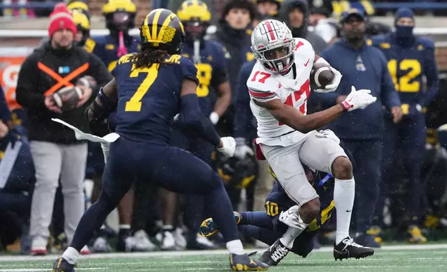 Ohio State wide receiver Carnell Tate, right, runs against Michigan defensive back TJ Metcalf during the first half of an NCAA college football game, Saturday, Nov. 29, 2025, in Ann Arbor, Mich. (AP Photo/Ryan Sun)