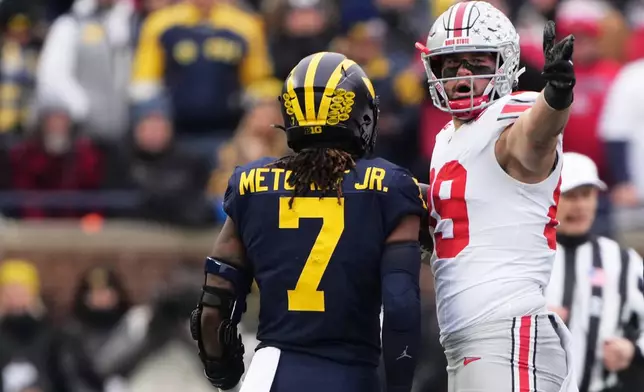 Ohio State tight end Will Kacmarek, right, celebrates near Michigan defensive back TJ Metcalf after a first down during the first half of an NCAA college football game, Saturday, Nov. 29, 2025, in Ann Arbor, Mich. (AP Photo/Ryan Sun)