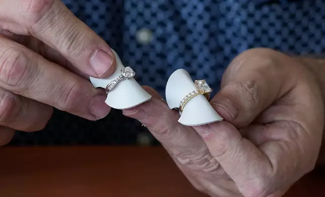 Ian Furman, a jewellery consultant, points out the difference between real, at right, and synthetic diamond used on engagement and wedding rings, in Johannesburg, South Africa, Thursday, Nov. 13, 2025. (AP Photo/Themba Hadebe)