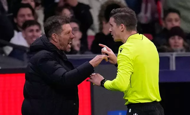 Atletico Madrid's head coach Diego Simeone speaks with referee François Letexier after receiving a yellow card during the Champions League opening phase soccer match between Atletico Madrid and Inter Milan, in Madrid, Spain, Wednesday, Nov. 26, 2025. (AP Photo/Manu Fernandez)