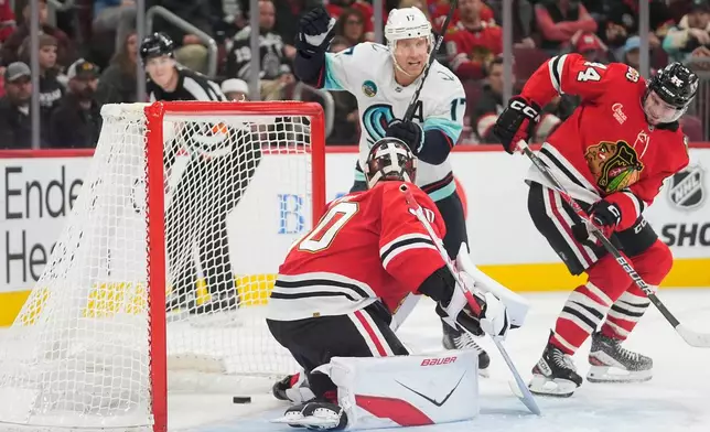 Seattle Kraken left wing Jaden Schwartz (17) scores against Chicago Blackhawks goaltender Spencer Knight, front left, during the third period of an NHL hockey game Thursday, Nov. 20, 2025, in Chicago. (AP Photo/Erin Hooley)