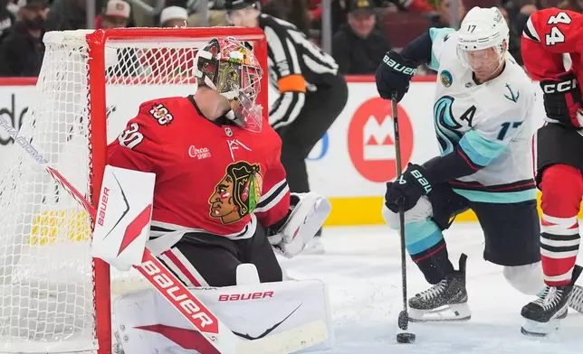 Seattle Kraken left wing Jaden Schwartz (17) scores against Chicago Blackhawks goaltender Spencer Knight, left, during the third period of an NHL hockey game Thursday, Nov. 20, 2025, in Chicago. (AP Photo/Erin Hooley)