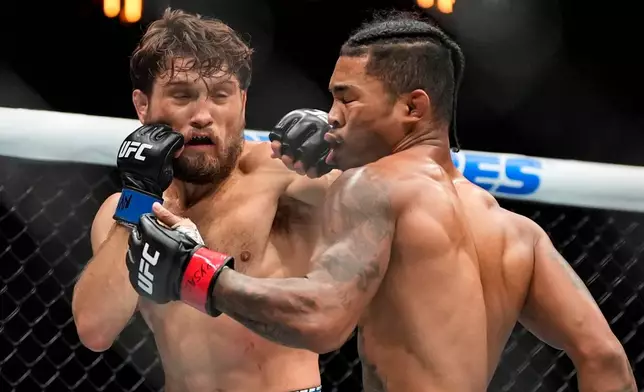 Ethyn Ewing, left, punches Malcolm Wellmaker, right, during the first round of a featherweight bout at the UFC 322 mixed martial arts event, Saturday, Nov. 15, 2025, in New York. (AP Photo/Yuki Iwamura)