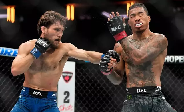 Ethyn Ewing, left, punches Malcolm Wellmaker, right, during the first round of a featherweight bout at the UFC 322 mixed martial arts event, Saturday, Nov. 15, 2025, in New York. (AP Photo/Yuki Iwamura)