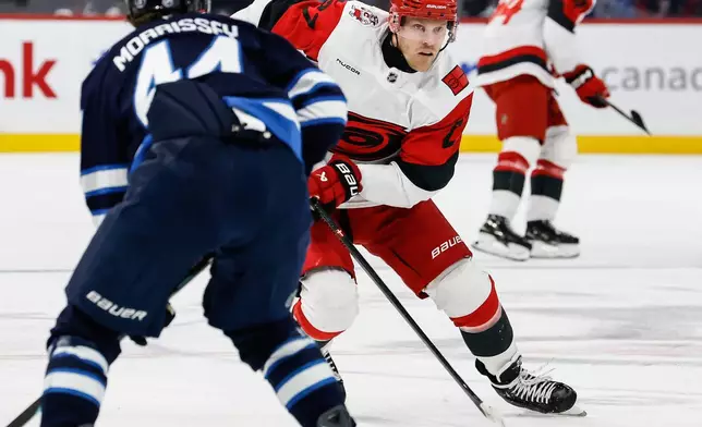 Carolina Hurricanes' Nikolaj Ehlers (27) passes the puck against the Winnipeg Jets during first-period NHL hockey game action in Winnipeg, Manitoba, Friday, Nov. 21, 2025. (John Woods/The Canadian Press via AP)