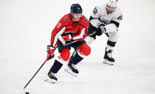 Washington Capitals right wing Ryan Leonard (9) skates with the puck against Los Angeles Kings left wing Kevin Fiala during the third period of an NHL hockey game, Monday, Nov. 17, 2025, in Washington. (AP Photo/Nick Wass)