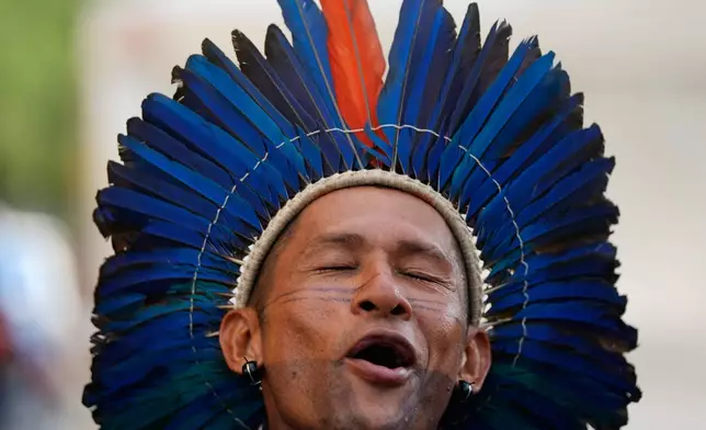 An Indigenous person sings and dances as they participate in an opening ceremony as part of the People's Summit offsite from the COP30 U.N. Climate Summit, Wednesday, Nov. 12, 2025, in Belem, Brazil. (AP Photo/Fernando Llano)