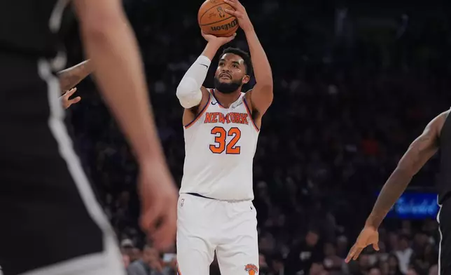 New York Knicks' Karl-Anthony Towns (32) shoots over Brooklyn Nets defenders during the first half of an NBA basketball game Sunday, Nov. 9, 2025, at Madison Square Garden in New York. (AP Photo/Frank Franklin II)