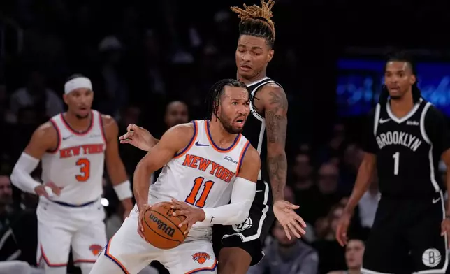 New York Knicks' Og Anunoby (8) knocks the ball away from Brooklyn Nets' Tyrese Martin (13) during the second half of an NBA basketball game Sunday, Nov. 9, 2025, at Madison Square Garden in New York. (AP Photo/Frank Franklin II)
