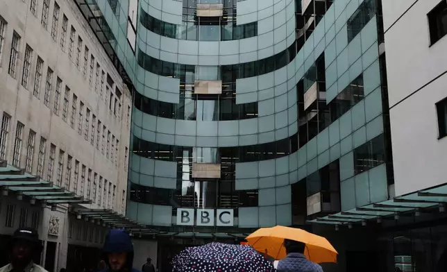 People walk outside BBC Broadcasting House in London, Tuesday, Nov. 11, 2025. (AP Photo/Kirsty Wigglesworth)