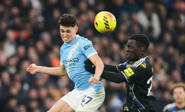 Manchester City's Phil Foden, left, challenges for the ball with Leeds' Wilfried Gnonto during the English Premier League soccer match between Manchester City and Leeds United in Manchester, England, Saturday, Nov. 29, 2025. (AP Photo/Ian Hodgson)