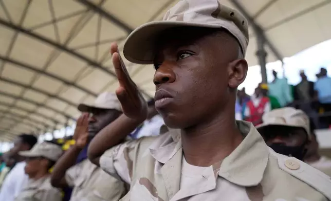 Tanzania security personnel salute as the national anthem is sung during the inauguration of Zanzibar President elect Hussein Ali Mwinyi of the ruling Chama Cha Mapinduzi (Revolutionary Party) at Amman Stadium in Zanzibar, Tanzania, Saturday, Nov. 1, 2025. (AP Photo/Brian Inganga)