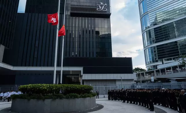 Chinese and Hong Kong Special Administrative Region flags fly at half-mast to mourn the victims of the deadly fire that started Wednesday at Wang Fuk Court, a residential estate in the Tai Po district of Hong Kong's New Territories, Saturday, Nov. 29, 2025. (AP Photo/Chan Long Hei)