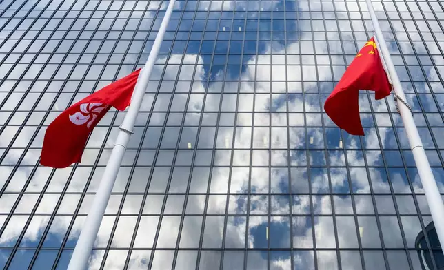 Chinese and Hong Kong Special Administrative Region flags fly at half-mast to mourn the victims of the deadly fire that started Wednesday at Wang Fuk Court, a residential estate in the Tai Po district of Hong Kong's New Territories, Saturday Nov. 29, 2025. (AP Photo/Chan Long Hei)