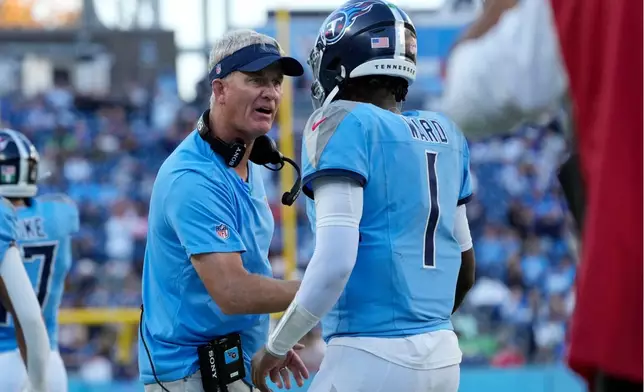 Tennessee Titans interim head coach Mike McCoy congratulates quarterback Cam Ward (1) after a touchdown against the Seattle Seahawks during the second half of an NFL football game Sunday, Nov. 23, 2025, in Nashville, Tenn. (AP Photo/George Walker IV)
