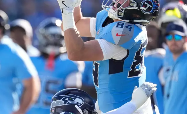 Seattle Seahawks linebacker Uchenna Nwosu, bottom, breaks up a pass intended for Tennessee Titans tight end Gunnar Helm (84) during the first half of an NFL football game Sunday, Nov. 23, 2025, in Nashville, Tenn. (AP Photo/George Walker IV)