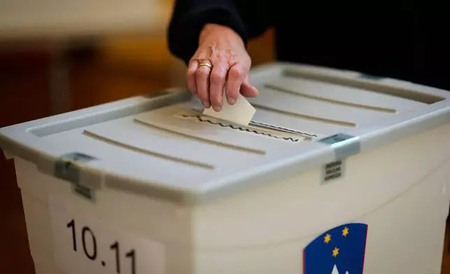 A voter casts her ballot at a polling station during the referendum on assisted dying for terminally ill patients, in Domzale, Slovenia, Sunday, Nov. 23, 2025. (AP Photo/Darko Bandic)