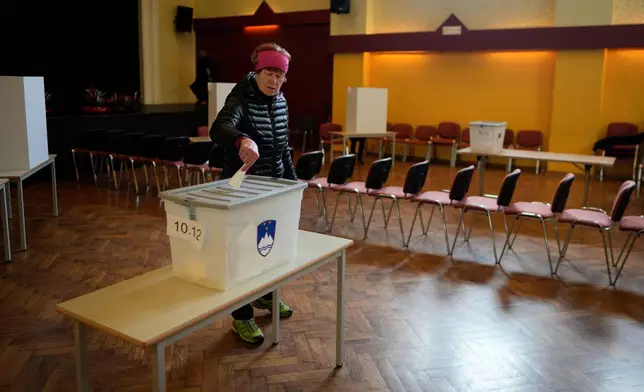 A voter casts her ballot at a polling station during the referendum on assisted dying for terminally ill patients, in Domzale, Slovenia, Sunday, Nov. 23, 2025. (AP Photo/Darko Bandic)
