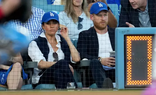 Prince Harry and Meghan Markle watch during the second inning in Game 4 of baseball's World Series between the Los Angeles Dodgers and the Toronto Blue Jays, Tuesday, Oct. 28, 2025, in Los Angeles. (AP Photo/Ashley Landis)